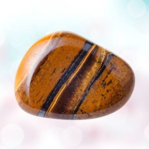 Discover the empowering magic of Tiger's Eye tumbles: a beacon of confidence, clarity, and protection in a chaotic world.